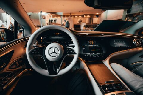 Blick ins Cockpit eines Mercedes EQS. Der Hyperscreen verleiht dem Innenraum ein futuristisches Ambiente. Der Bildschirm hinter dem Lenkrad kann umgeschaltet werden, von Tacho- auf Navigationsbetrieb.